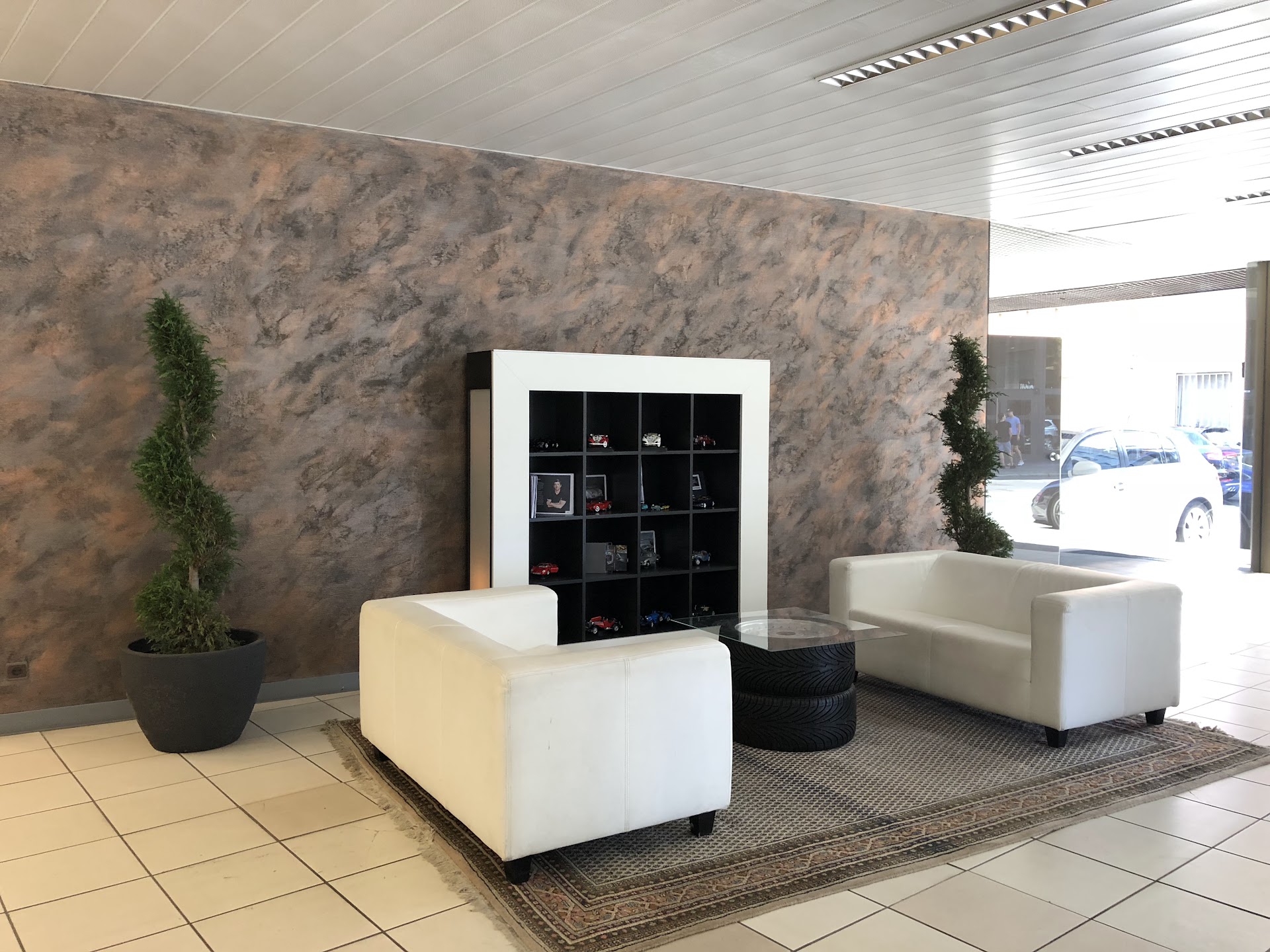 Lounge-Bereich im Autohaus mit Modellauto-Sammlung
